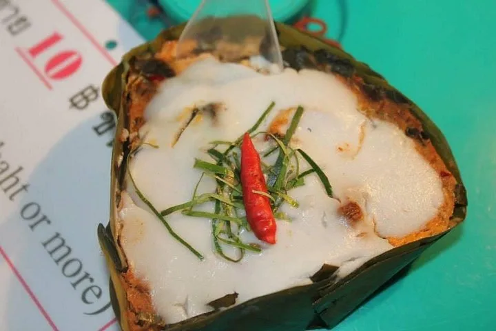A coconut dessert in a folded banana leaf