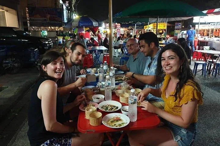 A small group sharing dishes at an open-air table