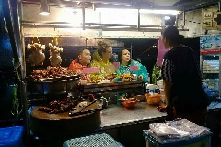 Roast ducks hanging above a night market counter