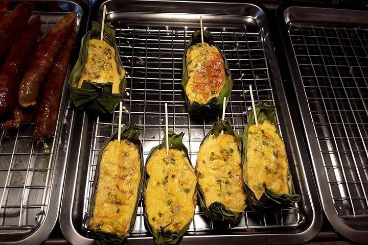 Egg custard baking in banana leaf cups over charcoal